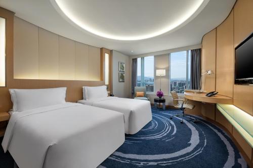 深圳Crowne Plaza Shenzhen Futian, Near by Futian Station and Coco Park, Outdoor Heated Pool的酒店客房配有两张床和一张书桌