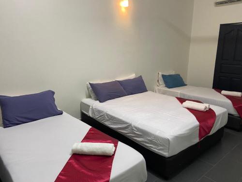 巴东勿刹Padang Besar Green Inn的客房设有两张单人床,备有毛巾。