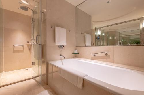 苏州苏州尼盛万丽酒店的带浴缸、淋浴和镜子的浴室