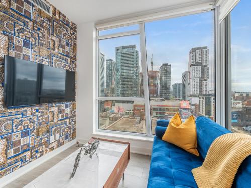 多伦多Boutique Vista Two Bedroom Suite - Toronto's Entertainment District的客厅设有蓝色的沙发和大窗户