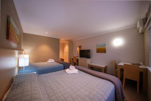 波拉尔帝国宾馆的酒店客房设有两张床、一张桌子和一间厨房。