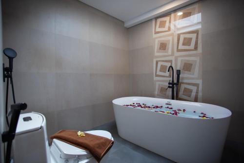 PereanGriya D'Carik的浴室设有白色浴缸,上面装有咖啡