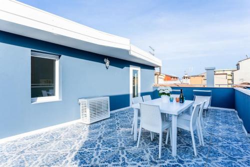 索托马里纳La Bella Vita - La Terrazza的蓝色墙壁上配有白色桌椅的庭院