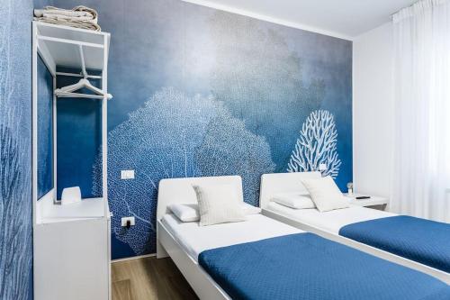 索托马里纳La Bella Vita - La Terrazza的一间卧室设有两张床和蓝色的墙壁