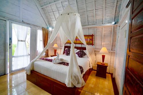 珀尼达岛Hotra Hill Cottage的一间卧室配有一张带蚊帐的床
