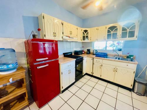 圣何塞德尔卡沃Casa Kante的厨房配有红色冰箱和白色橱柜