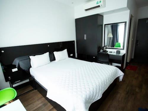 河内Ánh Hồng Hottel的卧室配有一张白色大床和镜子
