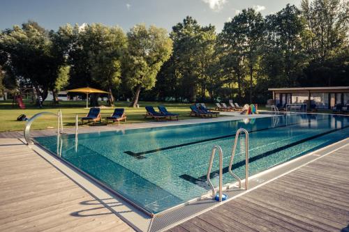 捷克布杰约维采Unikátní Chalet 6 vířivka & bazén的一个带蓝色椅子和木制甲板的游泳池