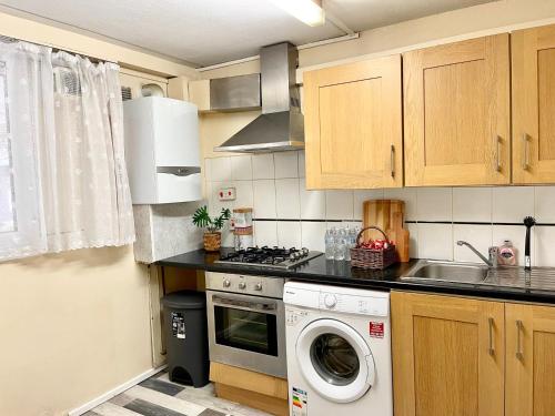 伦敦3BR flat in Central London close to Piccadily line的厨房配有炉灶和洗衣机。