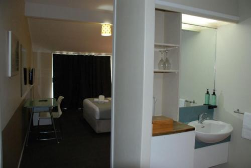奥克兰VR Auckland Airport的一间带水槽的浴室和一张位于客房内的床