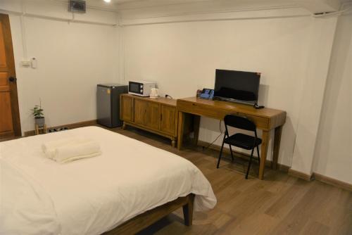 班敦孟BPP Resident near Donmueang Airport的一间卧室配有一张床和一张带电脑的书桌
