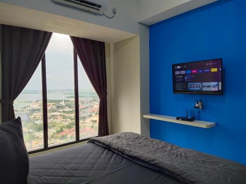 巴淡岛中心Comodo Apartemen Pollux Habibie Rooftop-SeaView的一间卧室设有蓝色的墙壁和大窗户