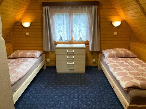 特罗亚诺维采Chata Koryška的一间卧室设有两张床和窗户。