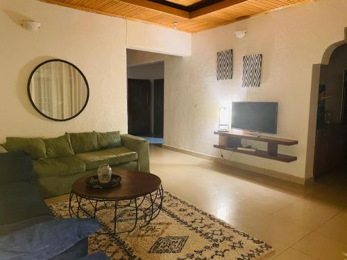 基加利grande villa verdoyante à louer pour 1 mois的客厅配有绿色沙发和电视