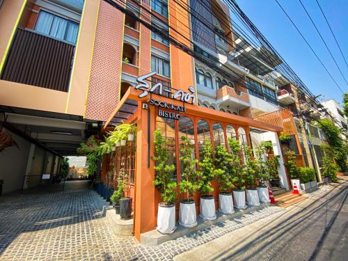 邦拉SO Zen Hotel Silom Bangkok的前面有一堆盆栽植物的建筑
