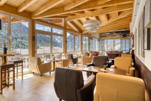 耶岑斯皇家阿尔卑斯山酒店的餐厅设有桌椅和窗户。