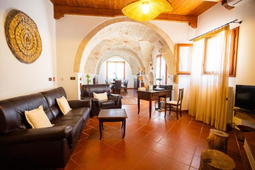 圣维托诺曼B&B Villa Mamma Grazia的客厅配有皮革家具和拱门