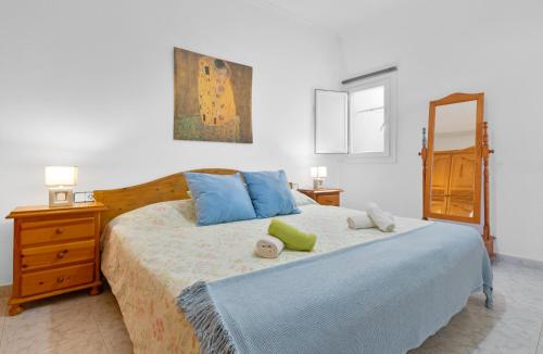 埃尔戈尔福Casita Isabella的一间卧室配有一张带蓝色枕头和镜子的床
