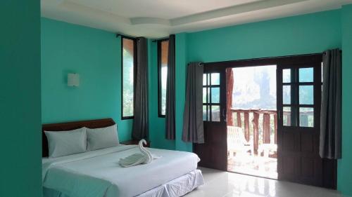 通塞海滩Garden View Resort Tonsai的一间拥有蓝色墙壁的卧室和一张带天鹅的床