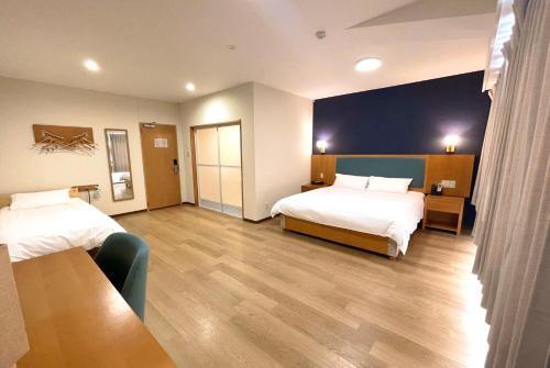 富士河口湖Fujinomori Hotel的酒店客房设有两张床和一张桌子。