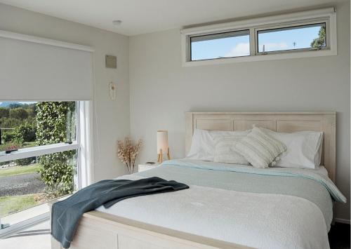 陶朗加Minden Meadows Retreat的白色卧室设有一张带窗户的床