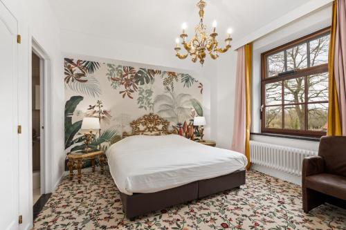 圣马尔滕斯·拉特姆托仁霍夫酒店的一间卧室配有一张床和一个吊灯