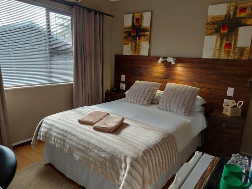 KraaifonteinVilla Mariss Guesthouse的一间卧室配有一张床,上面有两条毛巾