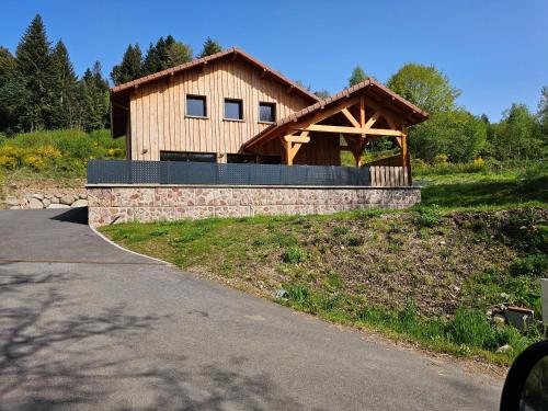 Gerbamont Gîte du Bambi的一座带石墙的大型木制房屋