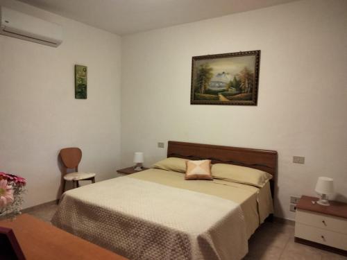 伊特里Casale di Valle Fredda的卧室配有一张床,墙上挂着一幅画