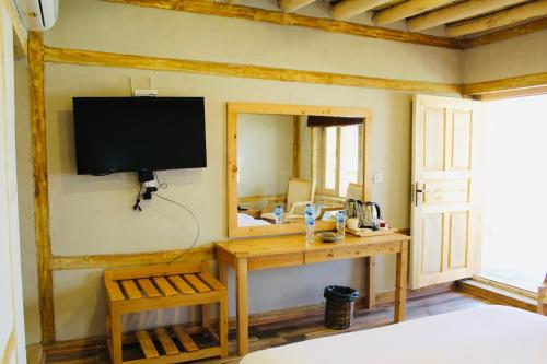 ShigarGuzel Hotel的卧室配有书桌和墙上的电视。