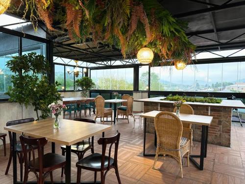 库塔伊西Hill Hotel的餐厅设有桌椅和窗户。