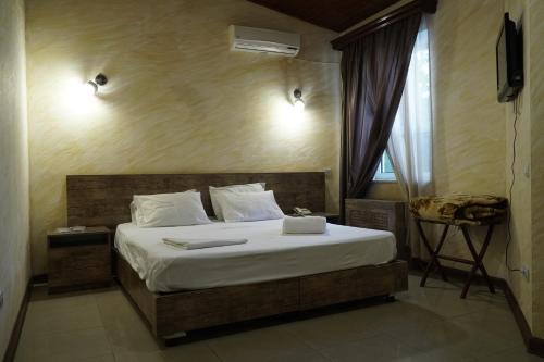 埃里温Aquapark Hotel & Villas的一间卧室配有一张带白色床单的床和一扇窗户。