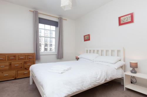 爱丁堡Attractive Edinburgh Leith Apartment的卧室配有白色的床和窗户。