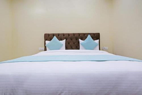 新德里Hotel Mannat at Paschim Vihar的一张带蓝色和白色床单及枕头的床