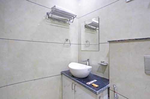 新德里Hotel Mannat at Paschim Vihar的白色的浴室设有水槽和镜子