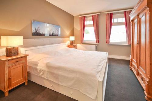 克伦胡森Maxi - Sonnenhof 4的卧室设有一张白色大床和两个窗户。