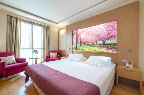穆尔西亚内尔瓦酒店的酒店客房设有一张床,墙上挂有绘画作品