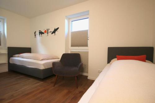 达默Dahmer Strand 8 - OCEAN TIME的卧室配有床、椅子和窗户。