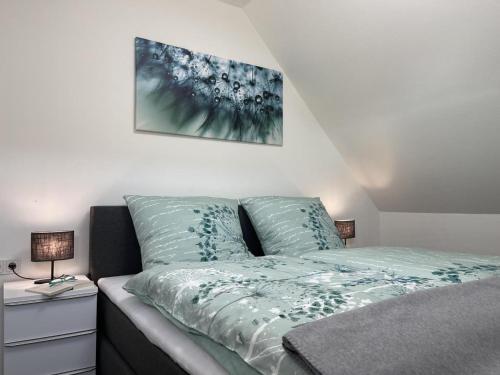 FedderwardersielAm Kutterhafen 17 - HAFENGLÜCK的一间卧室配有一张带蓝色床单的床和两盏灯。