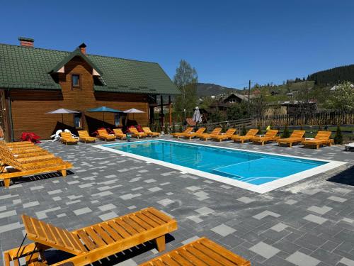 沃罗赫塔Готель Bliznuky的一个带躺椅的游泳池,一个度假村