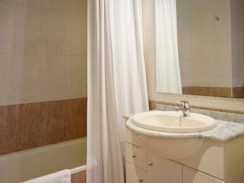萨拉戈萨Apartamentos El Pilar Suites 3000的浴室配有盥洗盆、镜子和浴缸