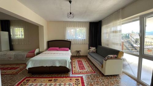 GökçeŞahan Apart的一间卧室配有一张床、一张沙发和一个窗口