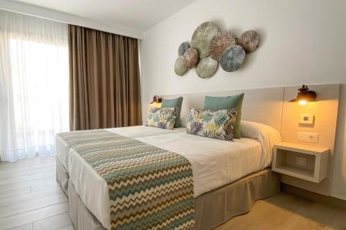 塔乌里托Apartamentos Cordial Magec Taurito的一间卧室配有一张大床和两个枕头