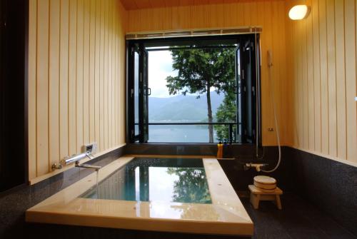 富士河口湖拉库玉旅馆的带浴缸和窗户的浴室