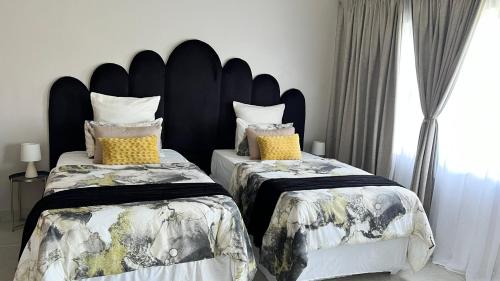 LobambaStronoff Stays的一间带两张床和大床头的卧室