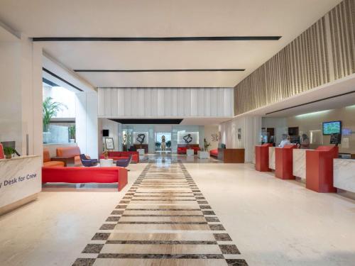 新德里ibis New Delhi Aerocity - An Accor Brand的大堂设有红色家具和 ⁇ 板地板