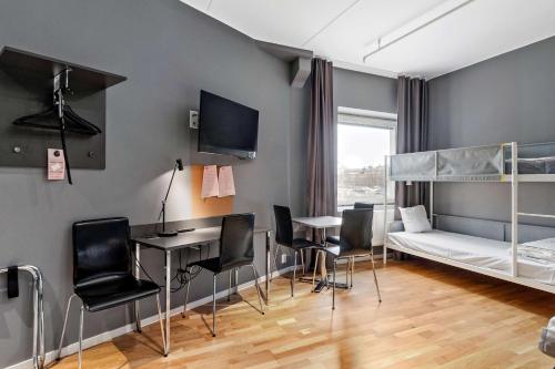 斯德哥尔摩Aiden by Best Western Stockholm Kista的一间卧室配有一张双层床和一张桌子及椅子