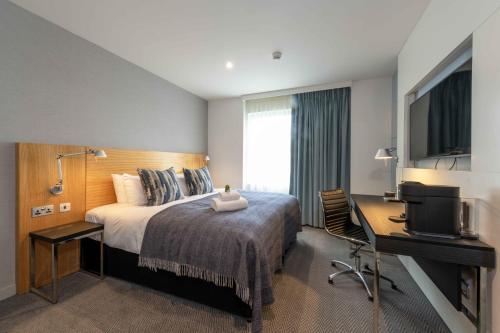 爱丁堡派克斯爱丁堡城市酒店的酒店客房配有一张床、一张书桌和一台电视。