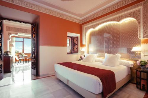 格拉纳达Alhambra Palace Hotel的一间卧室配有一张带橙色墙壁的大床