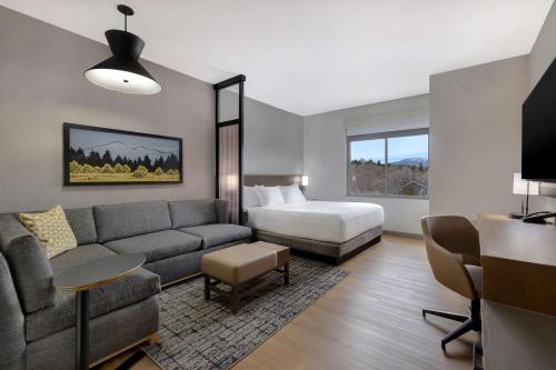 弗拉格斯塔夫Hyatt Place Flagstaff的客厅配有沙发和1张床